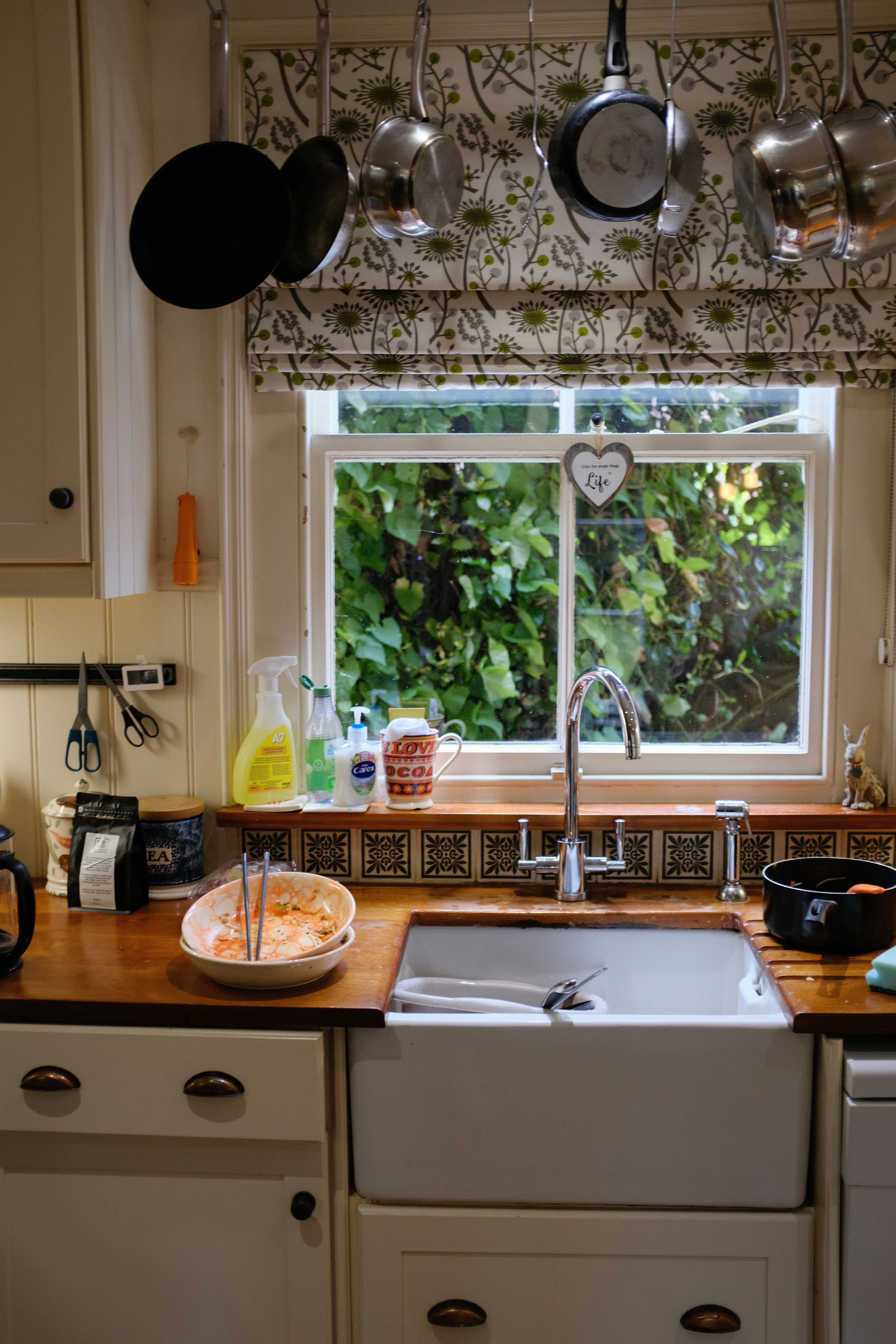 Home kitchen sink area after cooking with dishes ready to be washed and surfaces to be cleaned